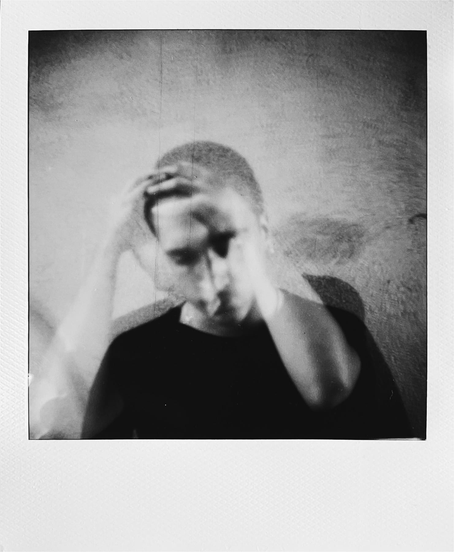 Polaroid en doble exposición con la mano sobre la cabeza