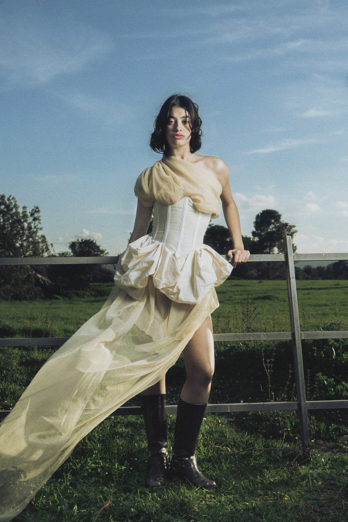 Vestido completo con cola de tul extendida sobre la cerca