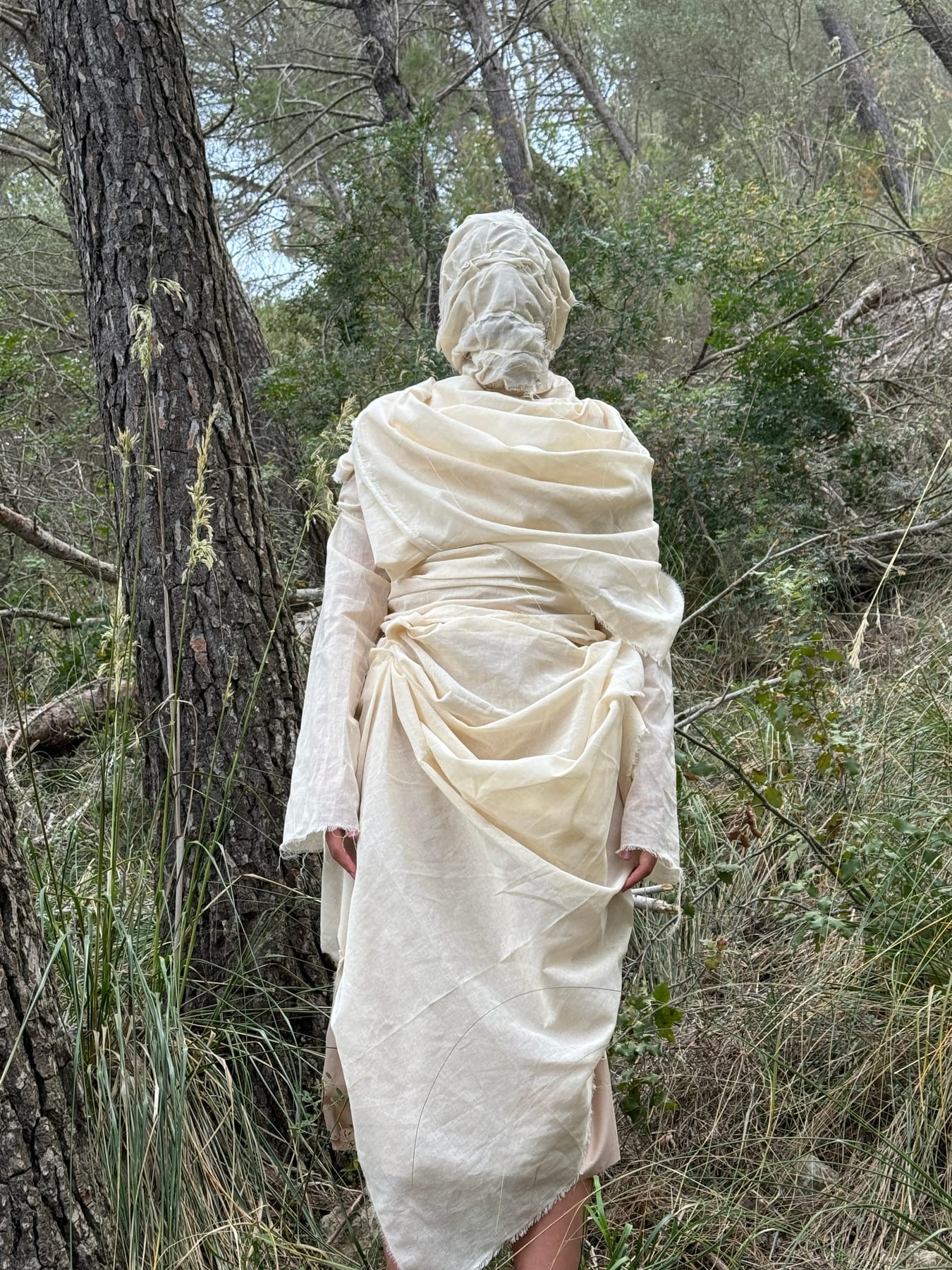 NIUMI — figura envuelta en tejido crudo en el bosque